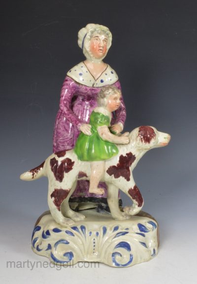 Staffordshire pearlware figure mother giving her child a ride on a dog, circa 1820