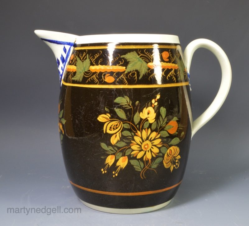 Pearlware pottery jug decorated with high fired enamels over a dark brown slip, circa 1820, perhaps Scottish