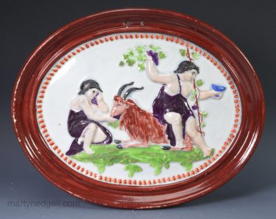Pearlware pottery plaque moulded with Bacchanalian boys, circa 1820