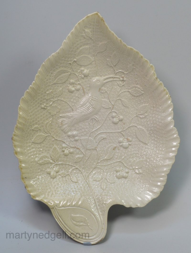 Staffordshire white saltglaze stoneware dish moulded with a bird eating berries, circa 1760