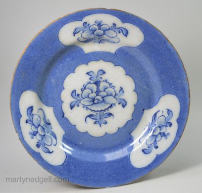 English delft plate decorated with blue flowers in reserves in a powder blue ground, circa 1740, possibly Wincanton