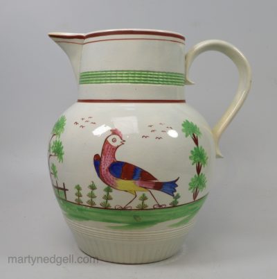 Pearlware pottery jug decorated with a bird in colours over the glaze, circa 1810
