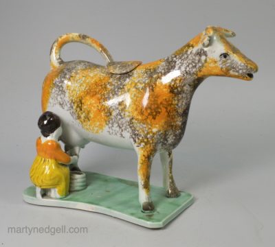 Pearlware pottery cobbled cow creamer decorated with colours under a pearlware glaze, circa 1820