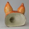 Oversize pearlware pottery fox head stirrup cup decorated with enamels over the glaze, circa 1820