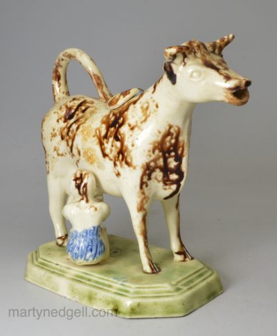 Creamware pottery cow creamer decorated with colours under the glaze, circa 1800