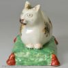 Staffordshire pearlware pottery cat on a tasseled cushion, circa 1820