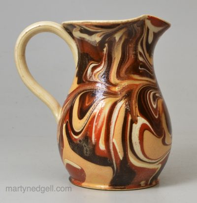 Small mochaware cream jug decorated with swirled slip over a creamware pottery body, circa 1800