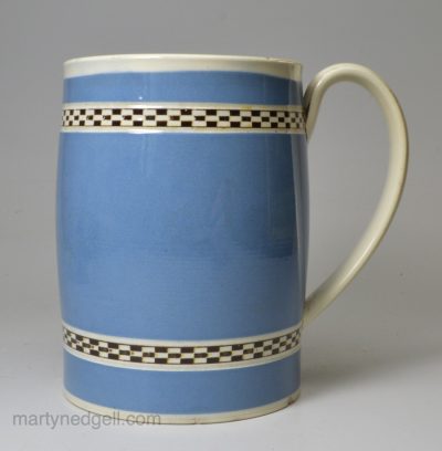 Pearlware pottery mug with light blue slip decoration and inlaid brown checker, circa 1800