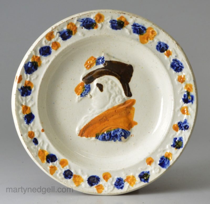 Small commemorative prattware pottery plate moulded with Queen Caroline, circa 1821