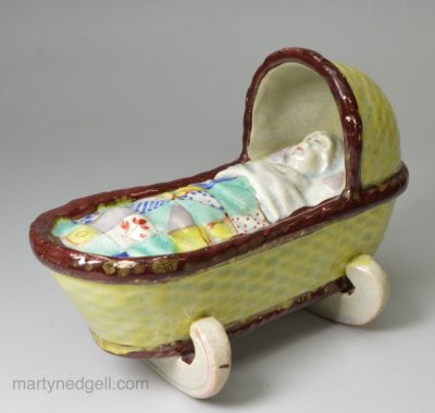 Pearlware pottery toy cradle with young girl, circa 1820