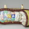 Pearlware pottery toy cradle with young girl, circa 1820