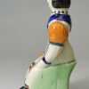 Prattware pottery figure of a seated woman, circa 1800