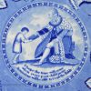 Pearlware pottery plate with an underglaze blue transfer print of George III giving the Bible to a poor child, circa 1820