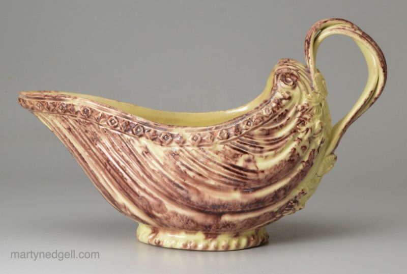 Creamware pottery moulded sauce boat with brown colouring under the glaze, circa 1770