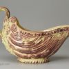 Creamware pottery moulded sauce boat with brown colouring under the glaze, circa 1770