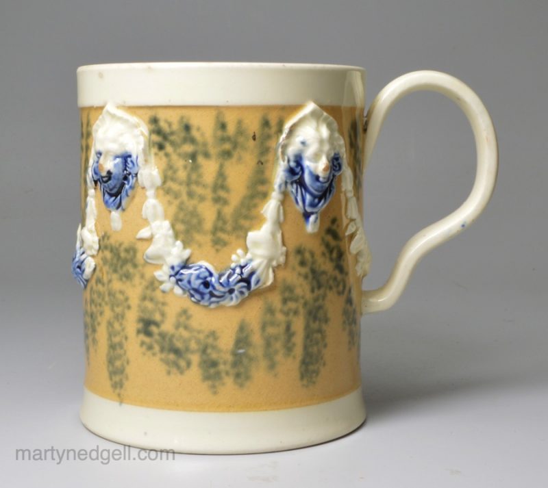 Creamware pottery mug decorated with tan slip and blue sponge marks under the glaze, circa 1790