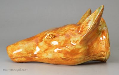 Pearlware pottery fox head stirrup cup decorated with a coloured oxide under the glaze, circa 1820