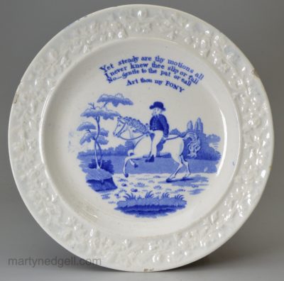 Pearlware pottery child's plate decorated with an underglaze blue transfer print 'Art thou my PONY', circa 1820