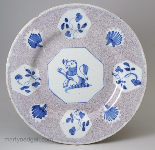 Bristol or Wincanton delft plate with a powder manganese ground and a family crest, circa 1740