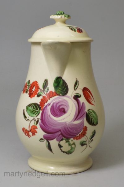 Creamware pottery milk jug and cover decorated with enamels over the glaze, circa 1780, probably Leeds Pottery