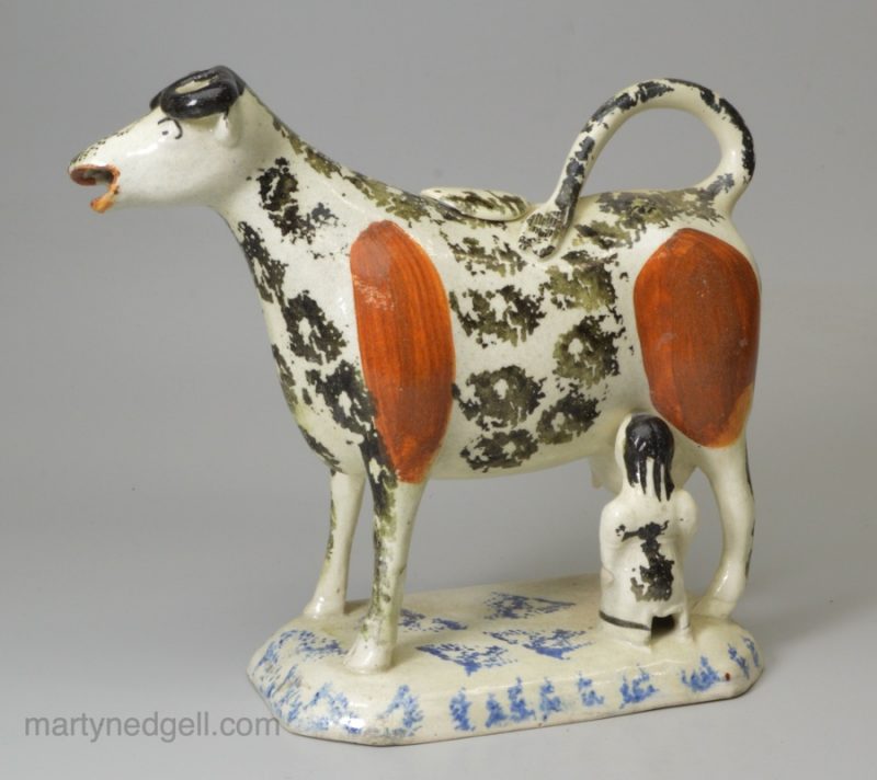 Pearlware pottery cow creamer decorated with colours under the glaze, circa 1820