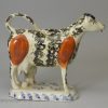 Pearlware pottery cow creamer decorated with colours under the glaze, circa 1820