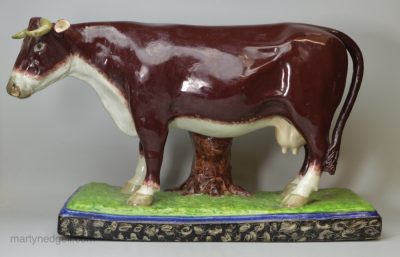 Oversize Staffordshire pearlware pottery cow decorated with overglaze enamels, circa 1820