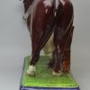 Oversize Staffordshire pearlware pottery cow decorated with overglaze enamels, circa 1820