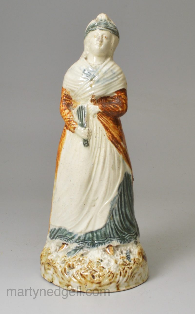 Pearlware pottery figure of a woman decorated with colours under the glaze, circa 1800