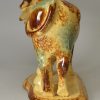 Buff coloured pottery cow creamer decorated with colours under the glaze, circa 1860