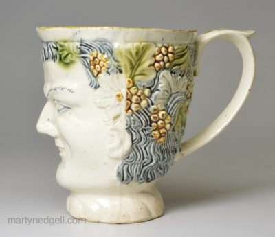 Creamware pottery Bacchus mug decorated with colours under the glaze, circa 1780