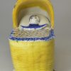 Prattware pottery toy cradle and baby, circa 1800, possibly Bovey Tracey