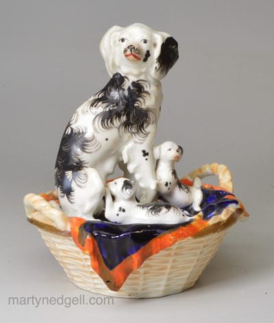 Staffordshire porcelain group of a spaniel and pups in a basket, circa 1840