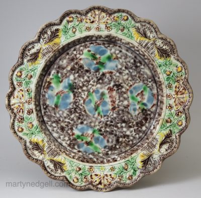 Creamware pottery plate decorated with a moulded butterfly border and Whieldon type glazes, circa 1770