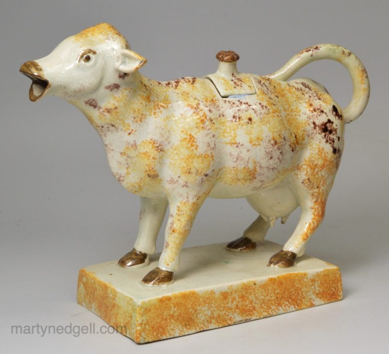 Pearlware pottery cow creamer decorated with colours under the glaze, circa 1820