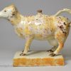 Pearlware pottery cow creamer decorated with colours under the glaze, circa 1820