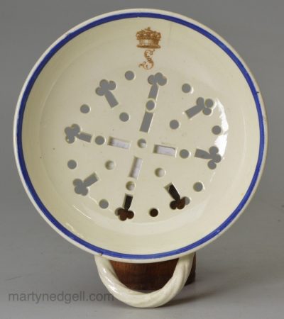 Creamware pottery strainer with a family crest, circa 1790