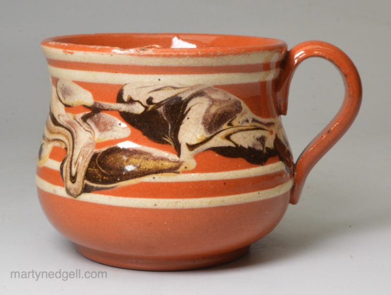 Brown pottery mug decorated with mocha snail trail, circa 1820