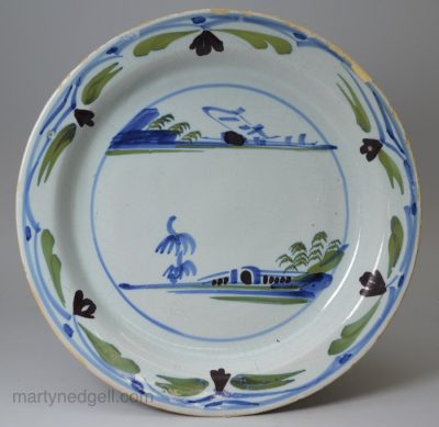 London delft pancake plate painted in blue, green and dark manganese, circa 1740