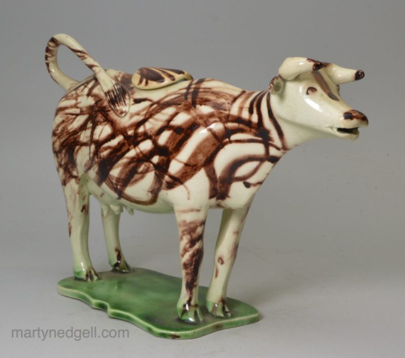 Pearlware pottery cow creamer decorated with colours under the glaze, circa 1810