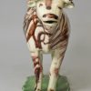 Pearlware pottery cow creamer decorated with colours under the glaze, circa 1810