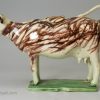 Pearlware pottery cow creamer decorated with colours under the glaze, circa 1810