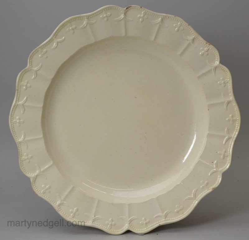 Creamware pottery dinner plate with a moulded border, circa 1780