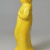 Canary yellow pottery figure of a woman and umbrella circa 1820