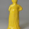 Canary yellow pottery figure of a woman and umbrella circa 1820