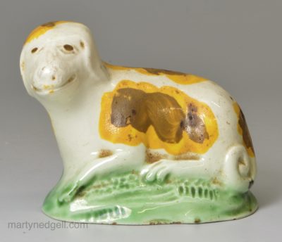 Small creamware pottery model of a dog decorated with colours under the glaze, circa 1790