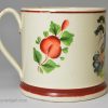 Creamware pottery mug decorated with a print of a drinking scene and coloured over the glaze, circa 1820