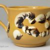 Small yellow bodied cup decorated with mocha slip, circa 1840