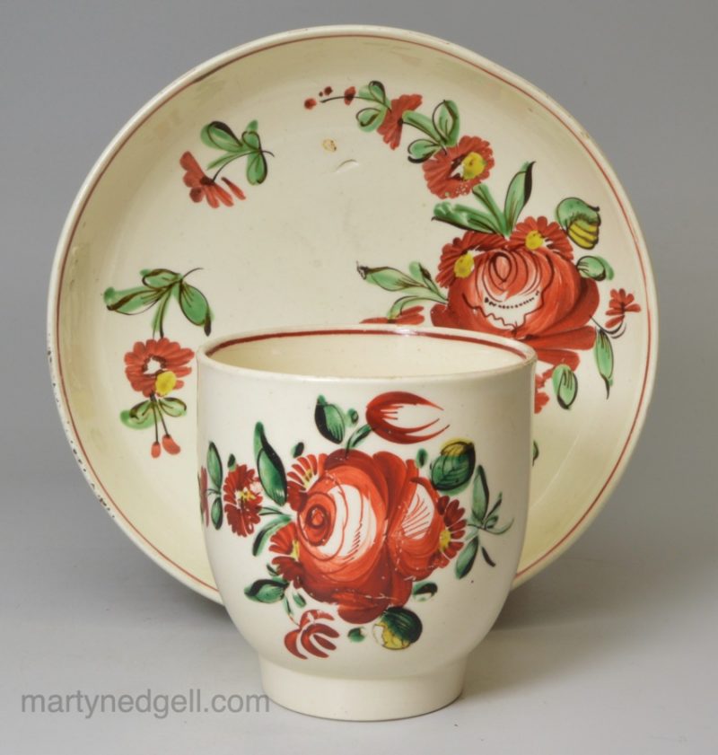 Creamware pottery coffee cup and saucer decorated with enamels over the glaze, circa 1780, probably Leeds Pottery