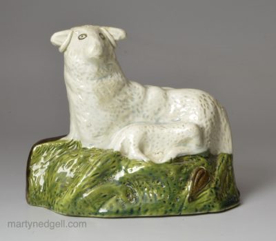 Pearlware pottery sheep and lamb decorated with colours under the glaze, circa 1800